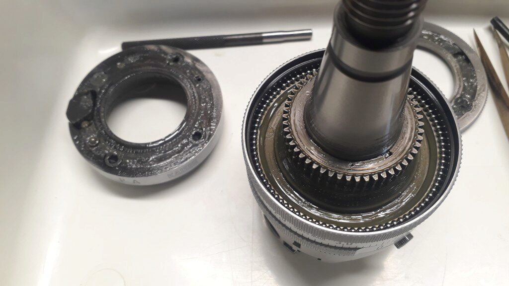 In the left, there is the second ring. In the right you
can see the bottom bearing and the two central gears. The top one
is attached to the shaft by a small key. Note the small hole that
is used to lock the top nut by inserting the pins. The bottom
gear, barely visible under the top gear, is attached to the third
ring and turns freely.