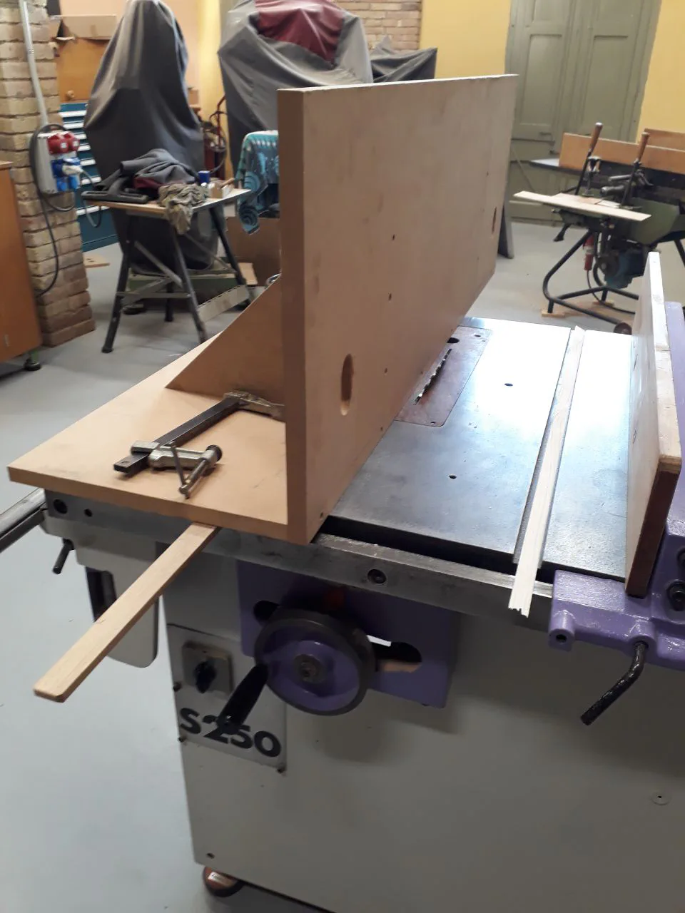 Moulding jig mounted on the saw table.
Note the inclination of the saw and the guide slots on the table